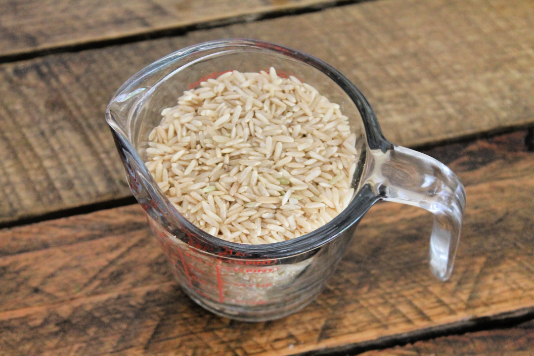 measuring cup with brown rice