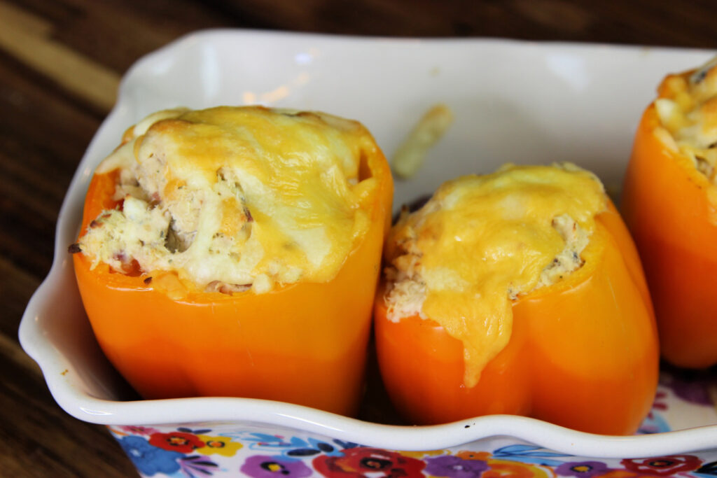 Chicken Bacon Ranch Stuffed Peppers baked with shredded chicken, cream cheese, ranch seasoning, crispy bacon, and melted cheddar cheese in orange bell peppers.