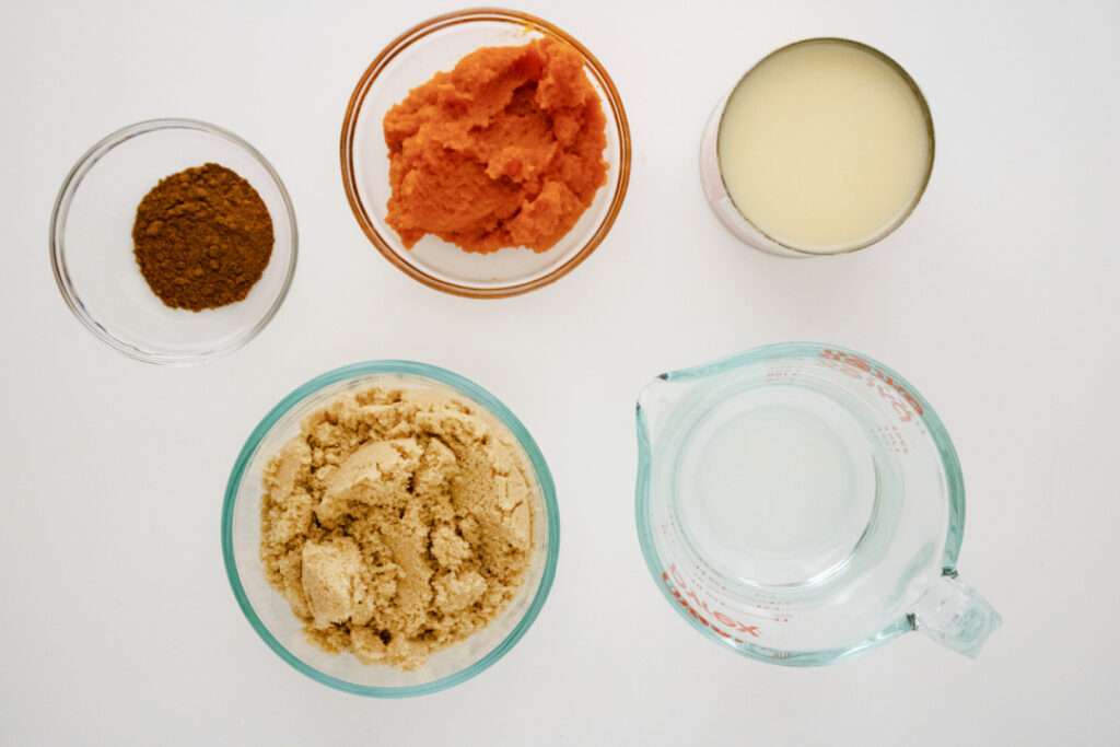 Ingredients for homemade pumpkin spice syrup including pumpkin puree, brown sugar, pumpkin pie spice, sweetened condensed milk, and water
