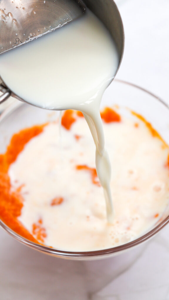 Milk being poured into pumpkin puree and egg for pumpkin pancake batter