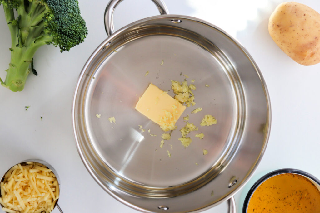 Butter and minced garlic melting in a Dutch oven to begin making homemade Broccoli Cheddar Soup.
