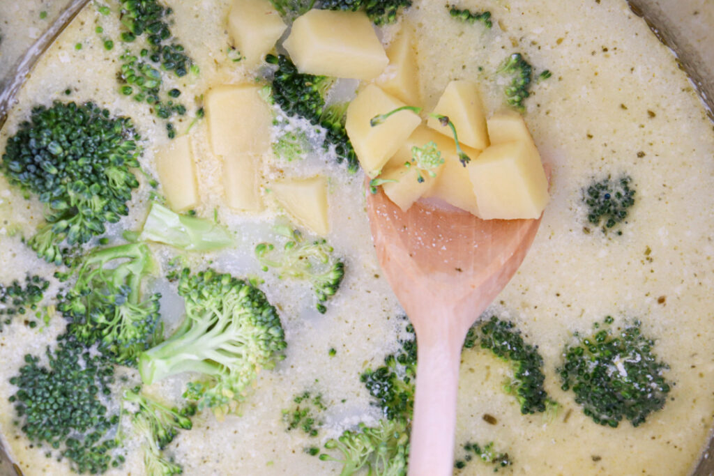 Diced potatoes and fresh broccoli simmering in the creamy broth for homemade Broccoli Cheddar Soup.