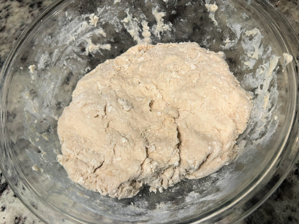 Freshly mixed basic white bread dough in a glass mixing bowl before kneading into a smooth, elastic dough.