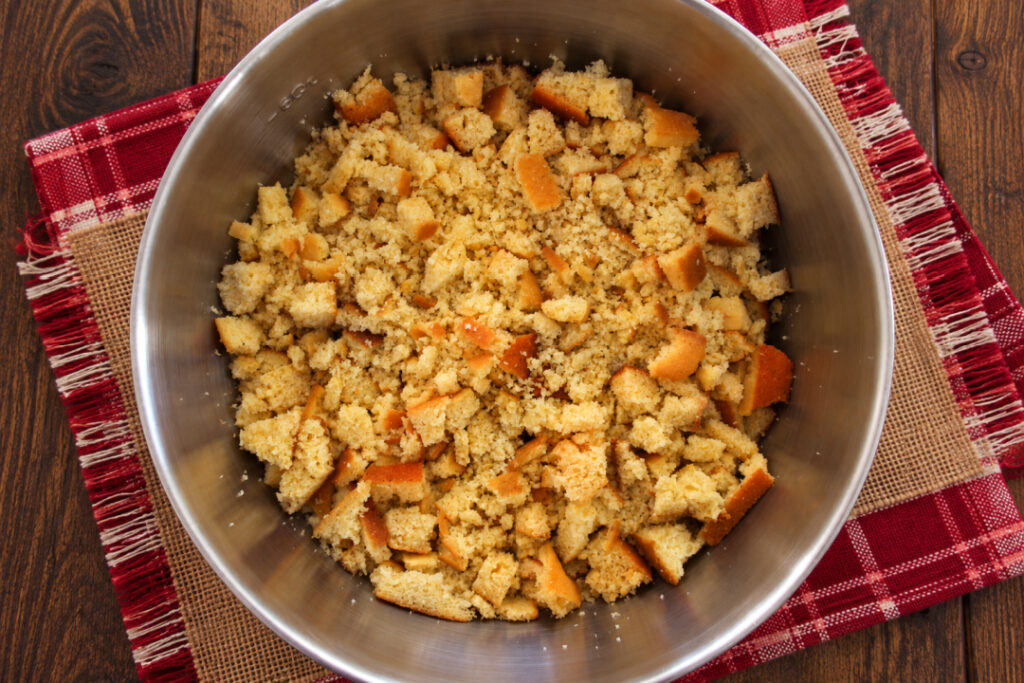 Crumbled cornbread, biscuits, and toasted bread in a large mixing bowl for Southern cornbread dressing.