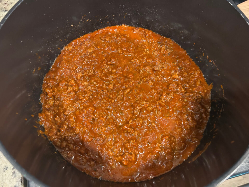 Ground beef mixed with tomato sauce and chili seasoning for easy beef and bean chili.